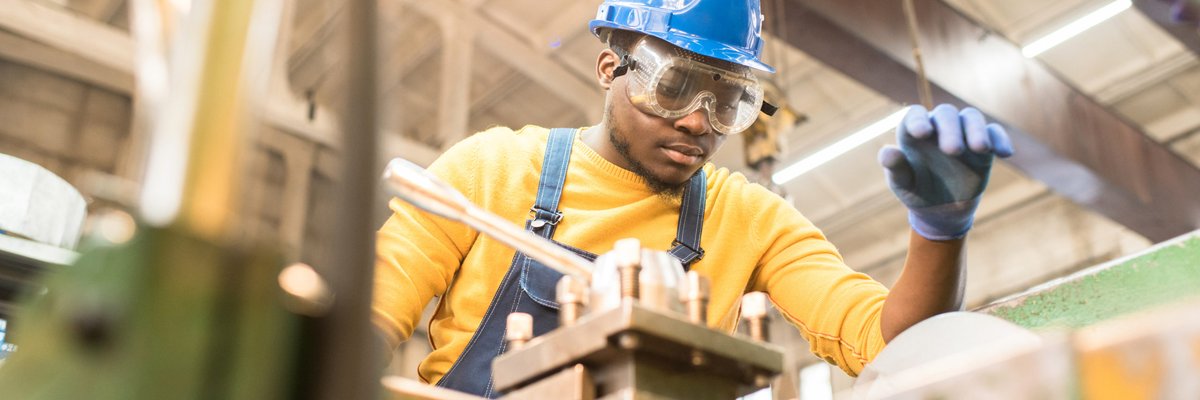 serious worker repairing manufacturing machine