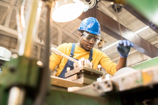 serious worker repairing manufacturing machine